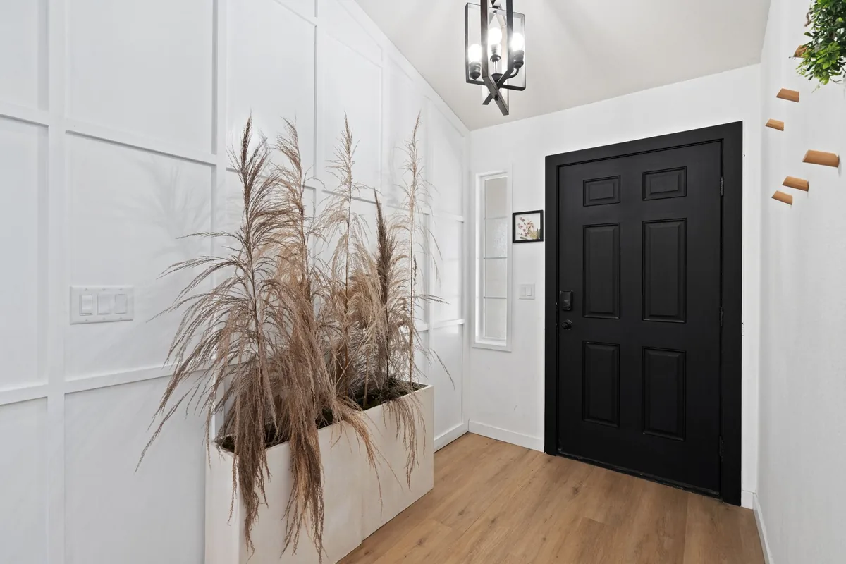 Internal door hung in a hallway with panelled walls and an oak floor