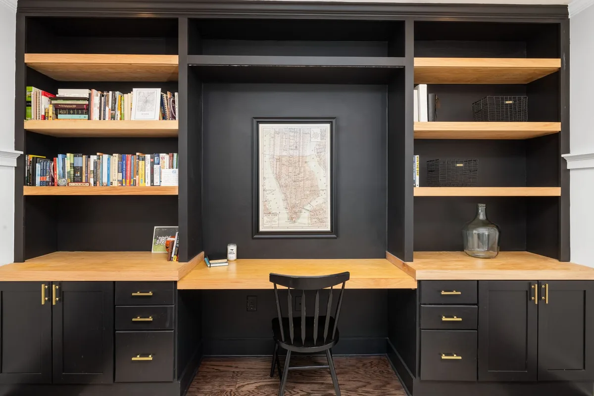 Built-in study with dark cabinetry, oak shelving and a fitted desk