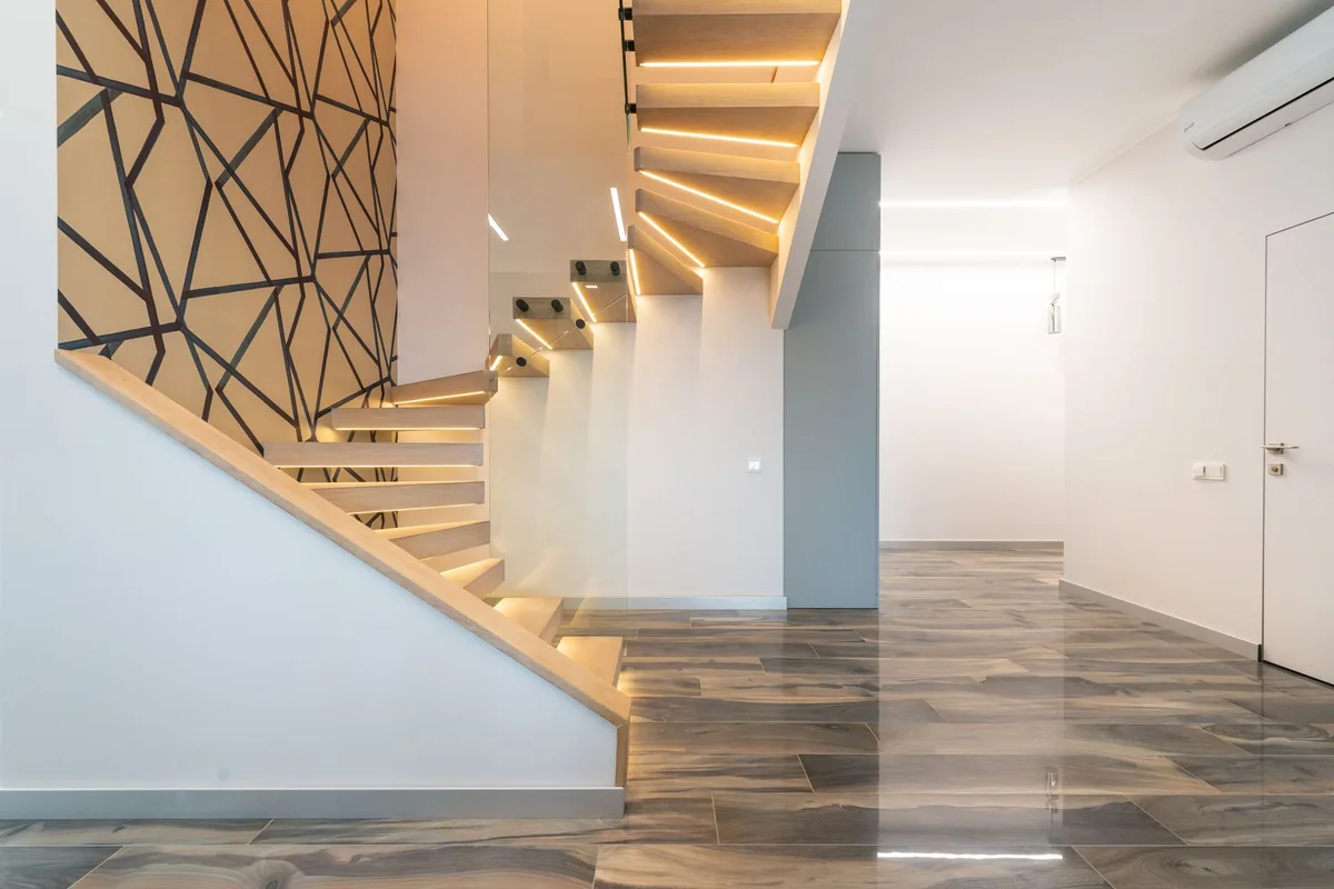 Open-tread timber staircase rising from an open-plan hallway