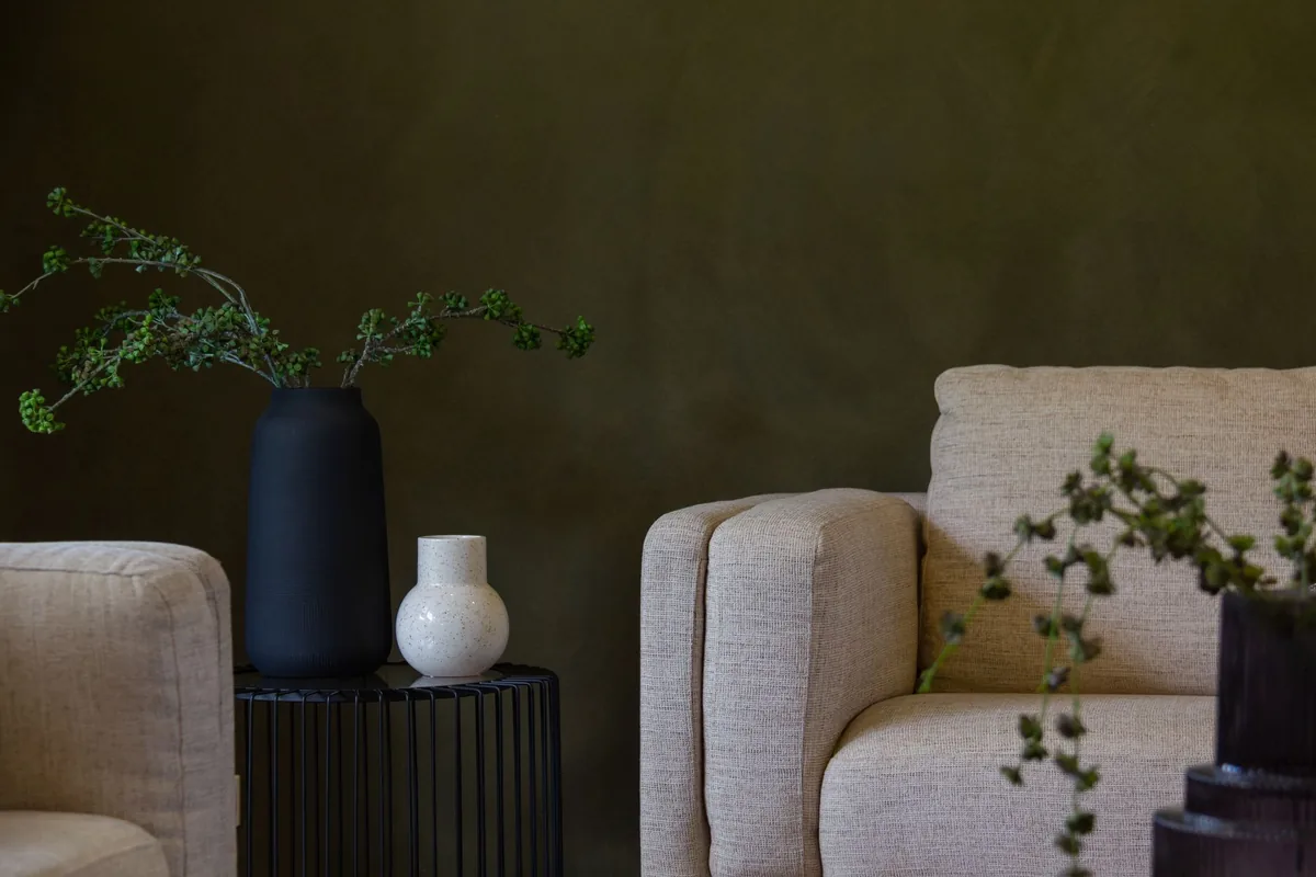 Sitting room with a dark green wall and fitted joinery detail