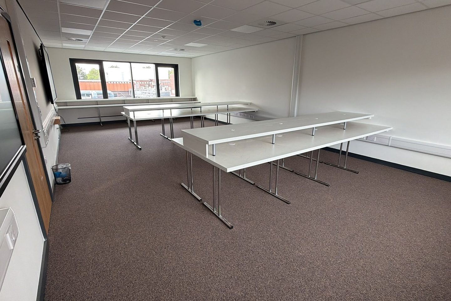 Two freestanding island benches and a window run in a finished training room
