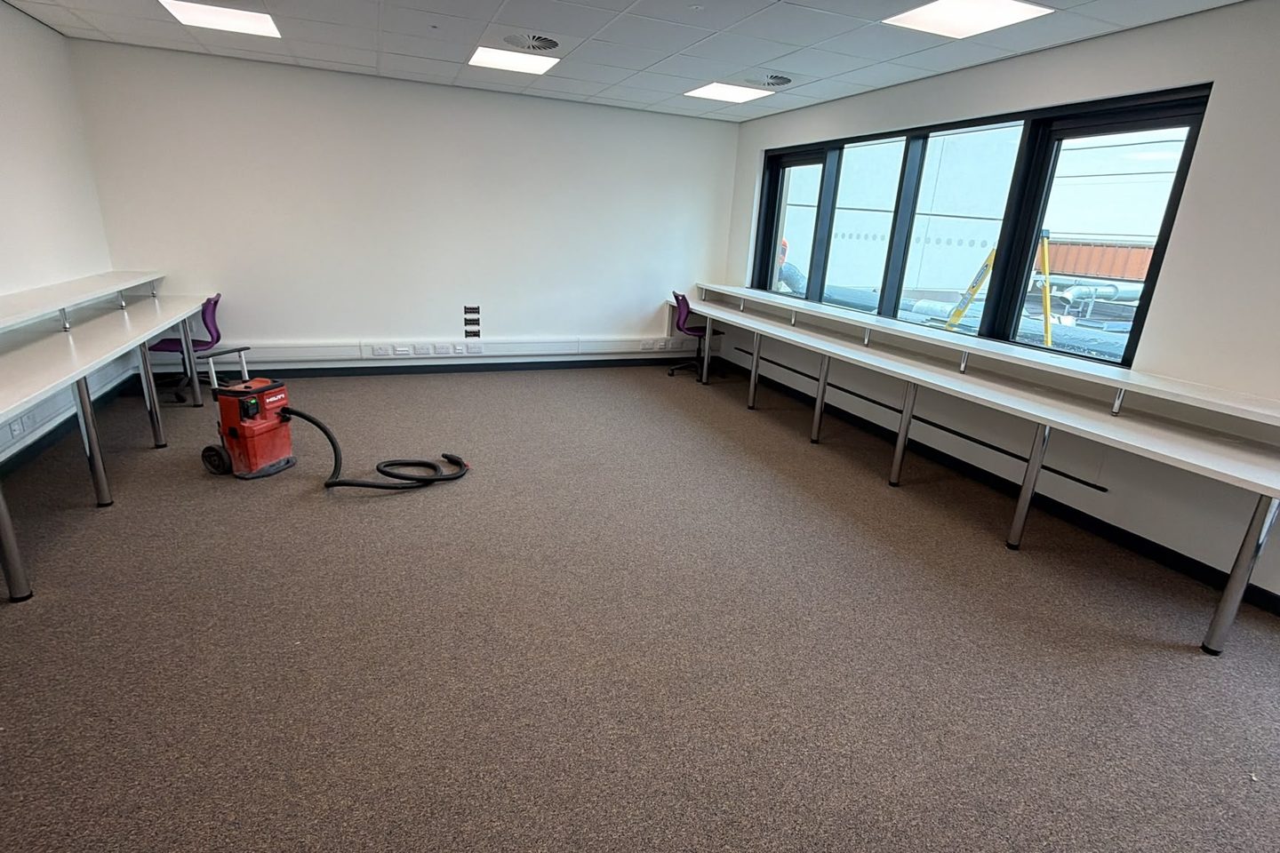 Training room with twin-tier benching run along two walls and under the windows